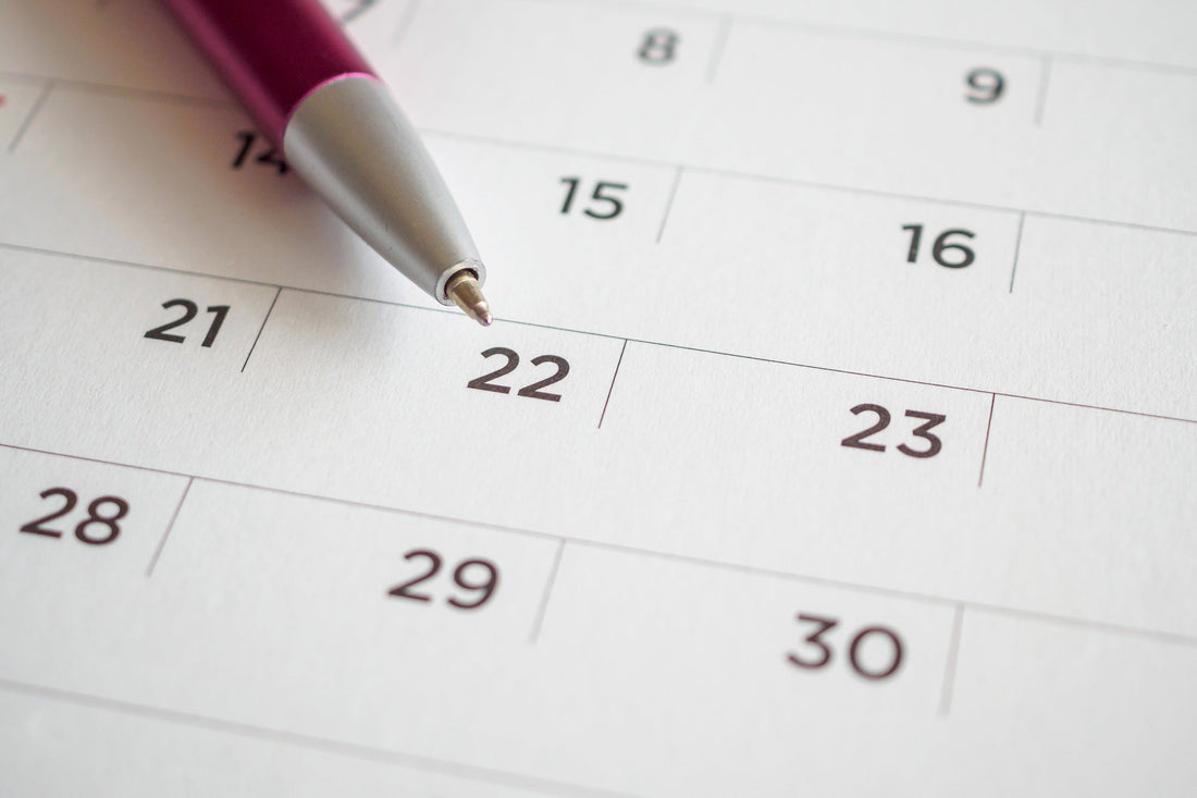 Stylo pointant une date entourée sur un calendrier, symbolisant la planification d'un congé de proche aidant