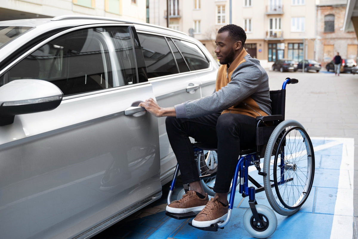 Personne en fauteuil roulant qui entre dans sa voiture