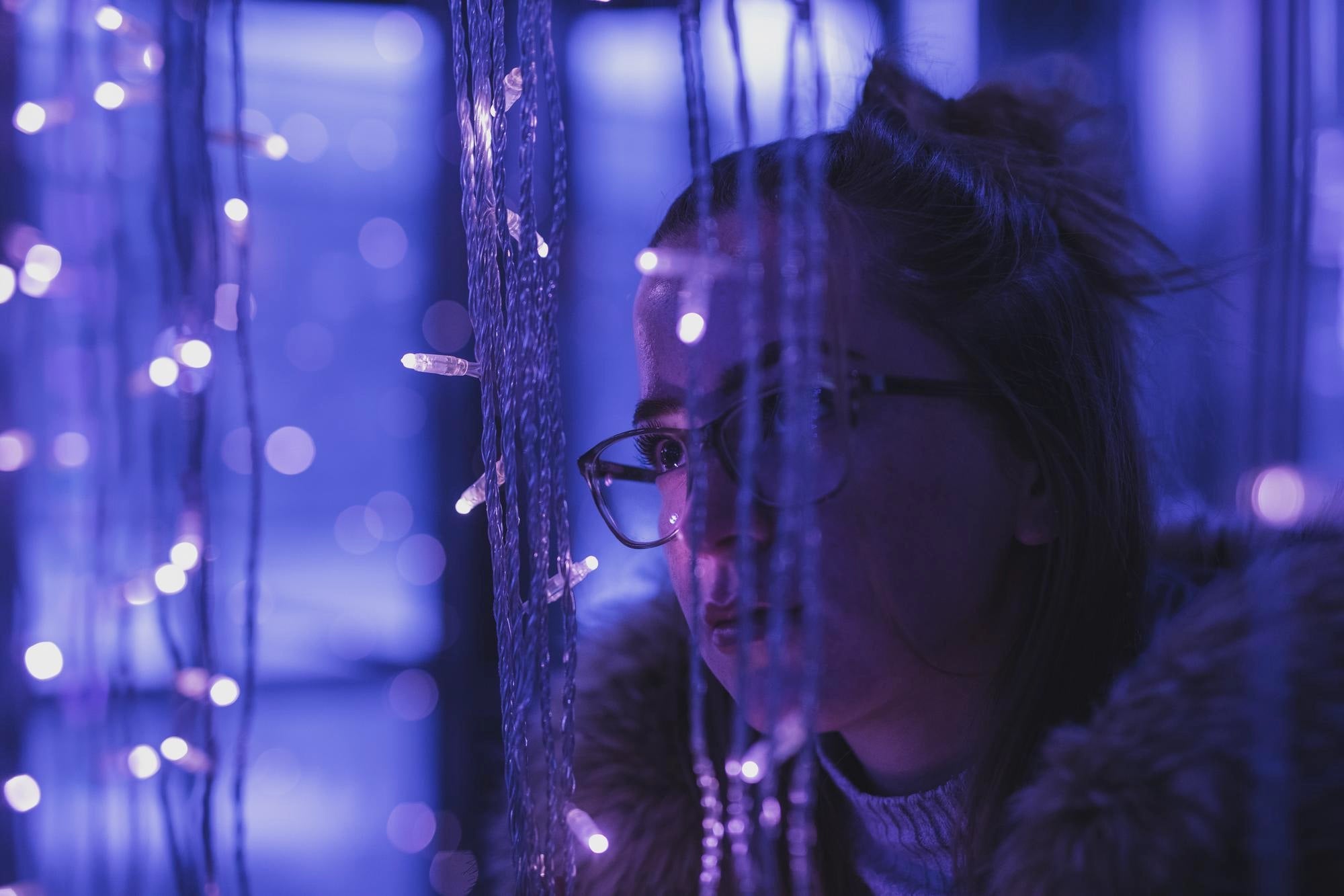 Jeune femme illuminé par des des lumières violettes et bleues