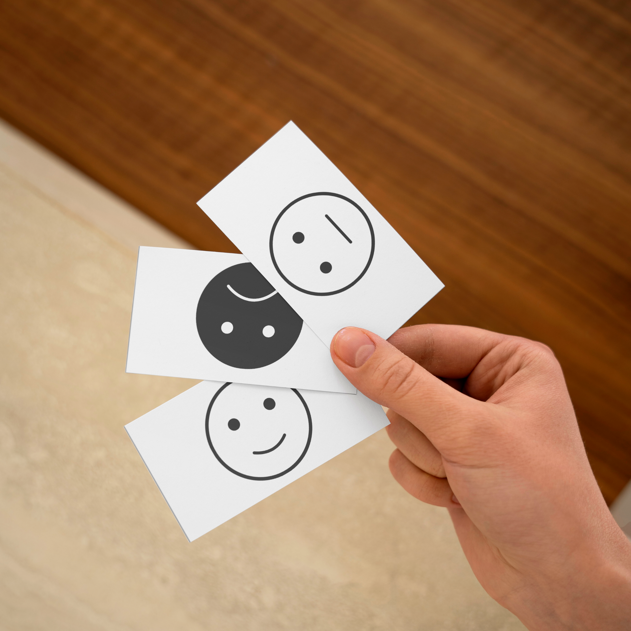 Trois carte des emotions echelle intensite noir et blanc dans une main 