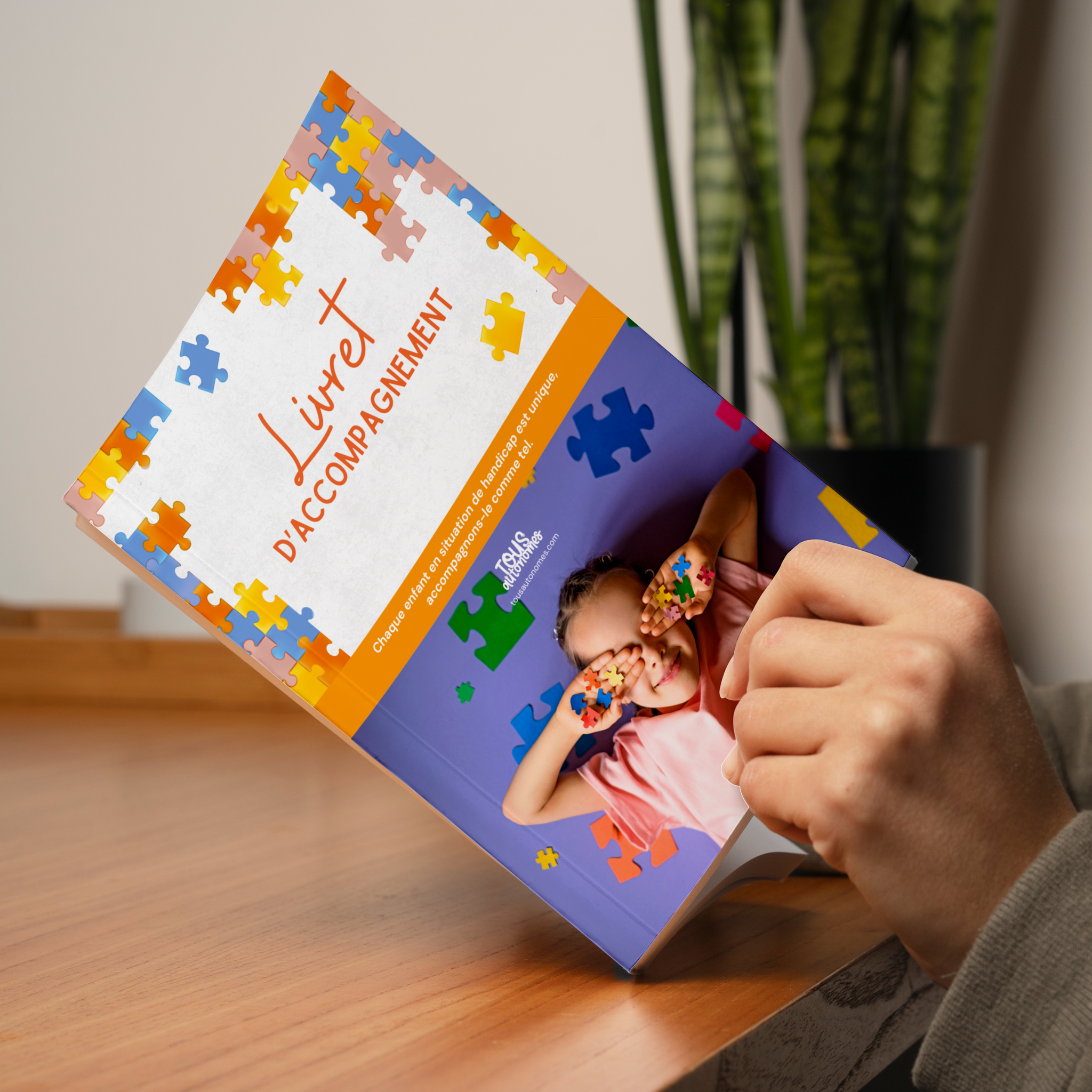 Couverture du livret d'accompagnement pour enfant en situation de handicap tenu dans des mains