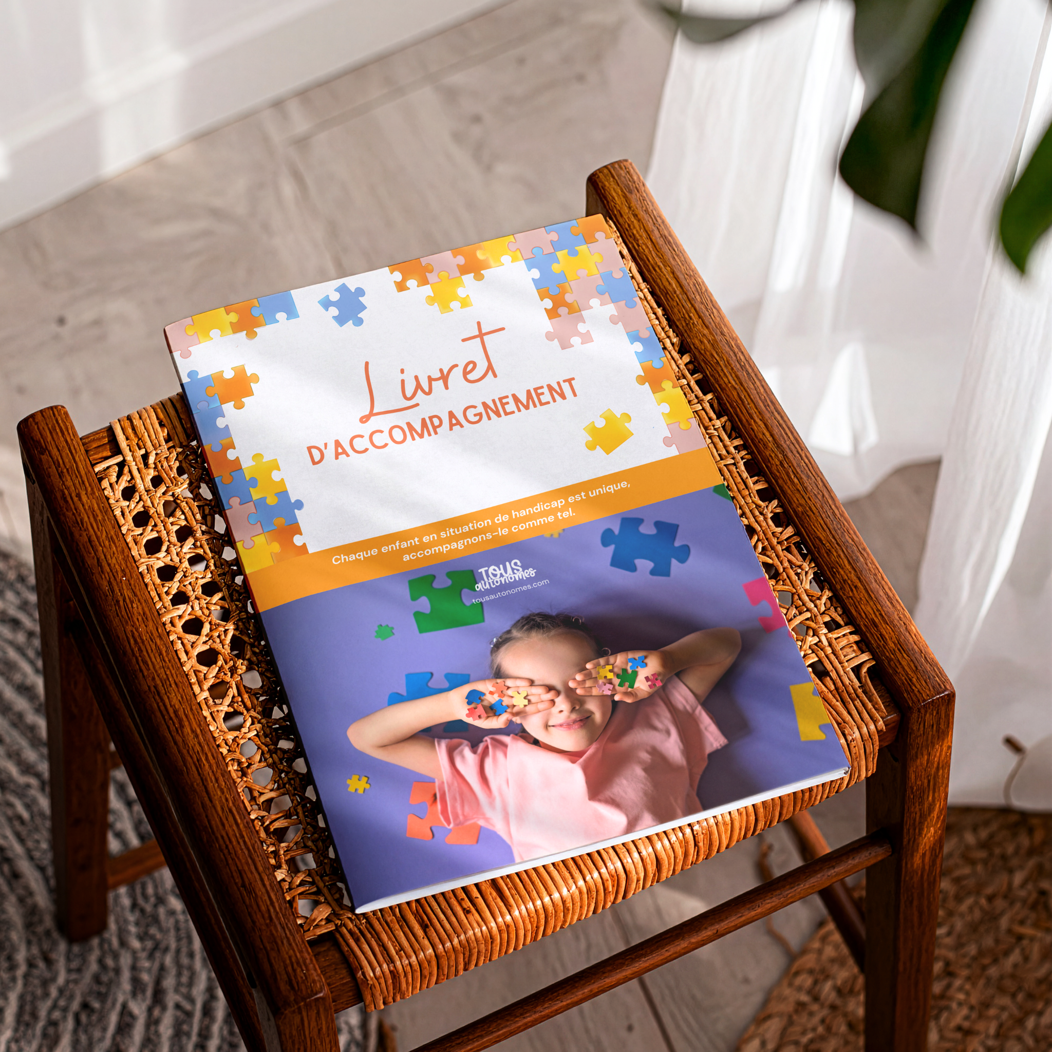Livret d'accompagnement pour enfant en situation de handicap posé sur un fauteuil 