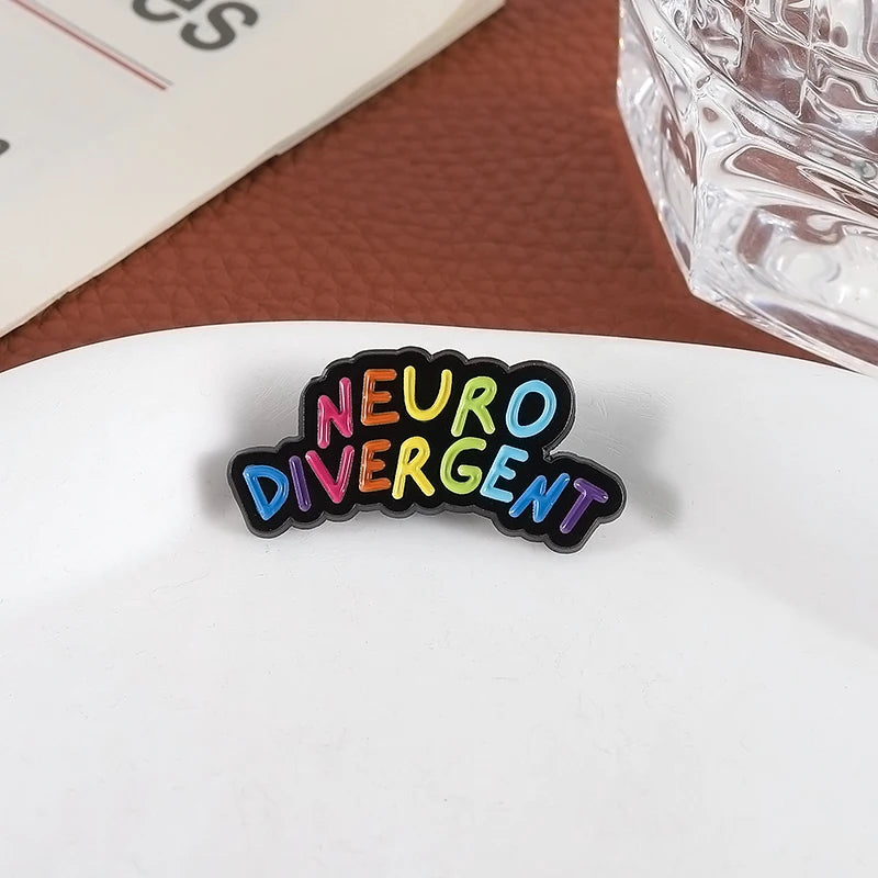 Pin's Neurodivergent posé sur une table 
